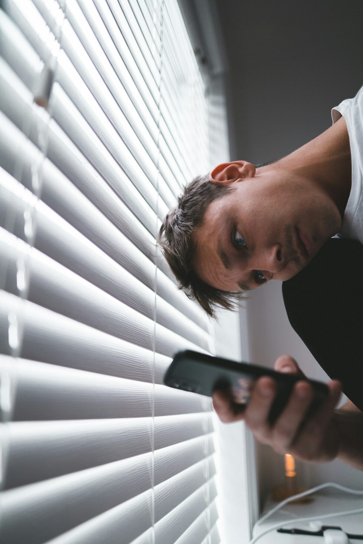 Man in morning daylight checking his phone — recognition moment for porn addiction symptoms